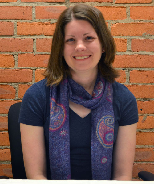 Staff headshot Katrina Folsom, in front of a brick background.