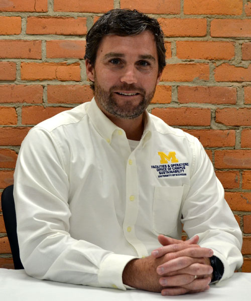 Staff headshot Kevin Morgan, in front of a brick background.