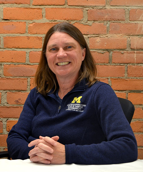 Staff headshot Nancy Fulcher, in front of a brick background.