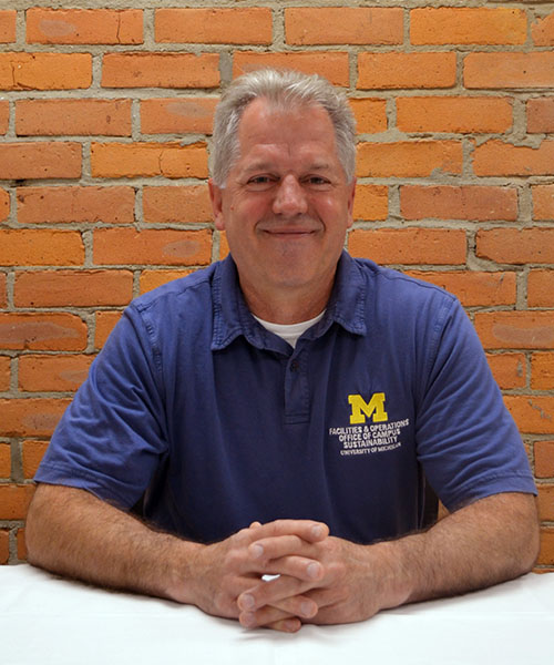 Staff headshot Steve Kunselman, in front of a brick background.