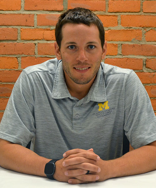Staff headshot Jack Gosselin, in front of a brick background.