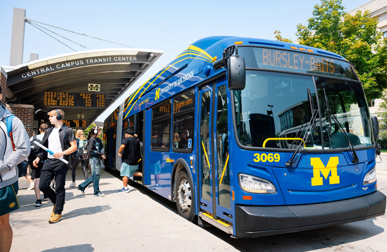 An electric bus picks up passengers from the bus depot.